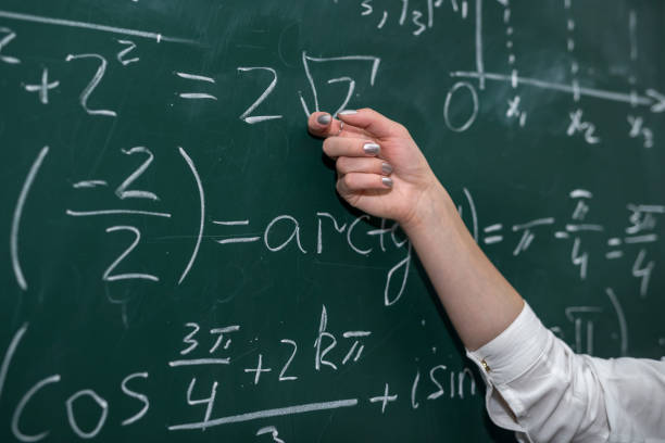 istock female hand showing math formula in chalkboard. Back to school 1292703573