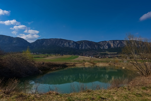 reflection from long rocky mountain range in a pond and landscape in the spring while hiking
