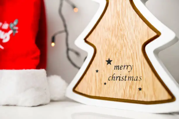 Close up image of christmas tree, christmas lights and Santa Clause hat on white background