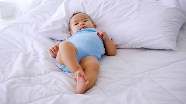 istock Adorable little baby lying on bed. 1292711602