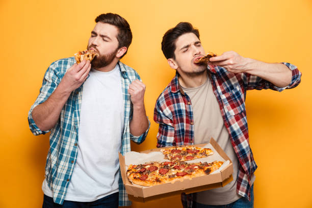 istock Two pleased men in shirt eating pizza 1292712349