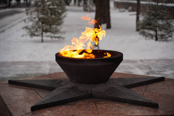 close up of perpetual fire in winter season. eternal flame burning in memory of those killed in second world war - chama eterna imagens e fotografias de stock