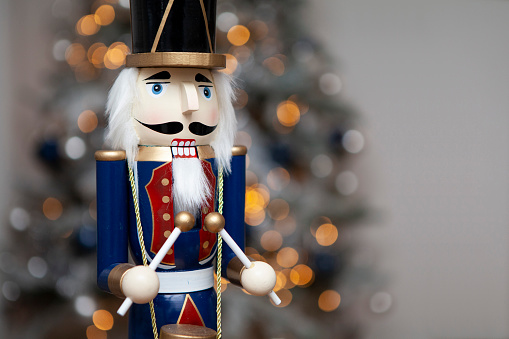Interesting beautiful christmas nutcracker soldier on red colored paper surface texture with copy space
