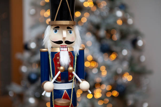 istock Soldier nutcracker statue in front of decorated Christmas tree with blurred lights 1292712800