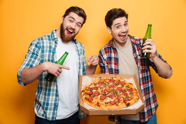 istock Two happy men with beer holding pizza 1292714169