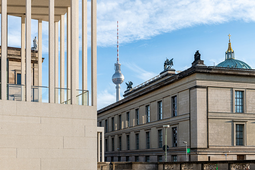 Berlin, Germany - December 20, 2020: view trough the columns of the James Simon Gallery at museum island in Berlin on old museum and Tv tower under blue december sky