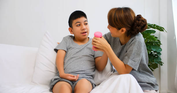 Disabled son has therapy by doing exercise with mother support and care.