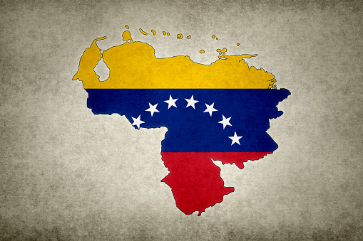 Grunge map of Venezuela with its flag printed within its border on an old paper.