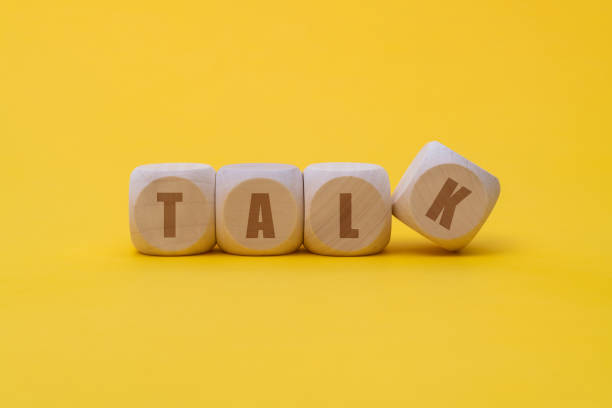istock Wooden cubes with word talk on yellow background 1292718191