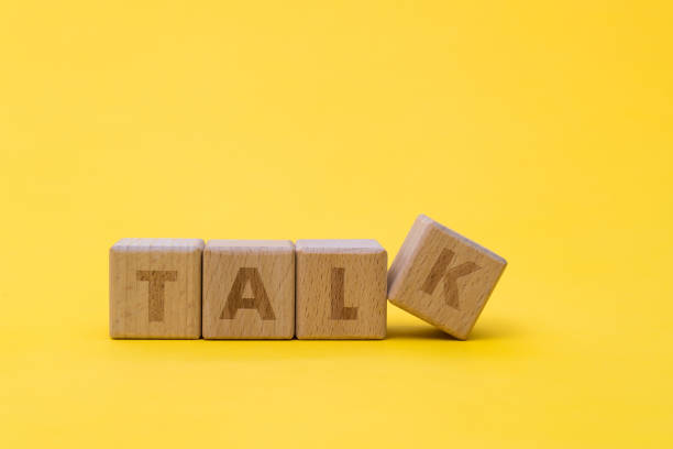 istock Wooden cubes with word talk on yellow background 1292718261