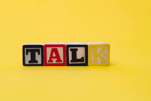 istock Wooden cubes with word talk on yellow background 1292718403