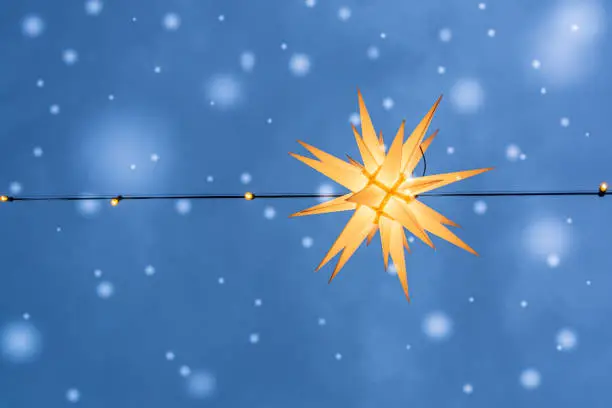 christmas star lighting with snow in the blue sky