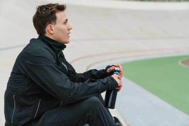 istock Young handsome man athlete resting at the stadium 1292721245