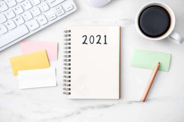 istock Top view of office table desk 2021 Goal work concept on bright marble white background. 1292721263