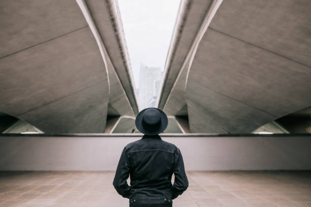 Rear view of man standing under a bridge