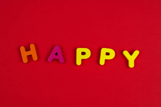 Wooden word happy on red background.