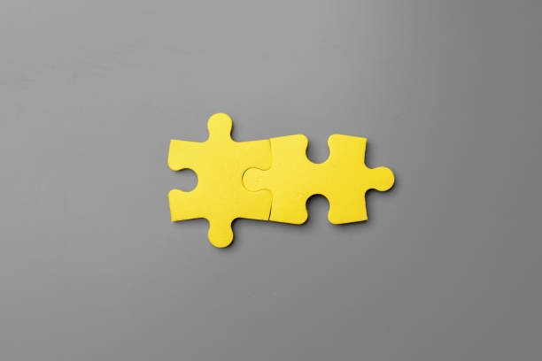 istock Yellow puzzle pieces on gray background close up 1292723608