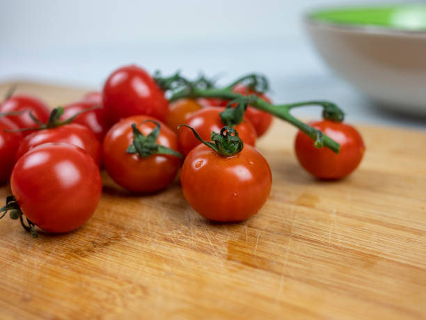 istock several red cherry tomatoes. Fresh tasty tomatoes on the board 1292723962