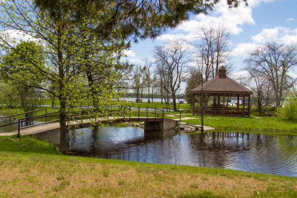 Van Cleve City Park In Gladstone Michigan Pavilion and footbridge over a small pond with a wooden gazebo in the small Upper Peninsula town of Gladstone near Escanaba, Michigan. gladstone michigan stock pictures, royalty-free photos & images