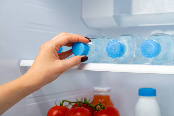 istock Female hand taking bottle of water from a fridge 1292726501