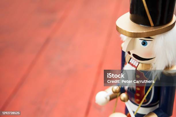 Closeup Of A Wooden Soldier Nutcracker Figurine On A Red Wooden Surface With Copy Space Stock Photo - Download Image Now