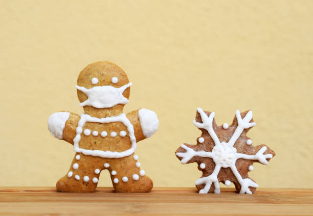 istock Gingerbreads decorated with white icing - man with protective face mask and snowflake 1292728688
