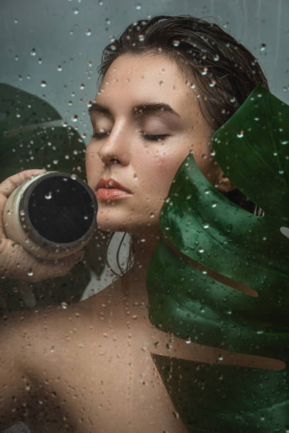 hermosa mujer con una hoja tropical capturada a través de vidrio húmedo - leaf epidermis fotografías e imágenes de stock