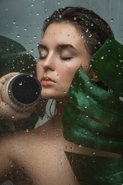 beautiful woman with a tropical leaf captured through wet glass - leaf epidermis imagens e fotografias de stock