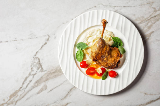 istock Duck confit with parsnip puree and orange sauce cherry tomatoes, fresh spinach 1292729861