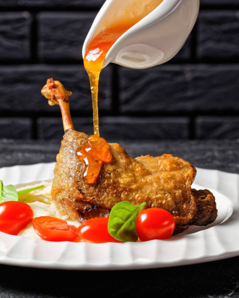 istock Duck confit with parsnip puree and orange sauce cherry tomatoes, fresh spinach 1292729956