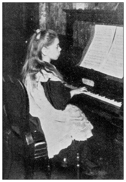 istock Antique dotprinted black and white photograph: Girl playing piano 1292732250