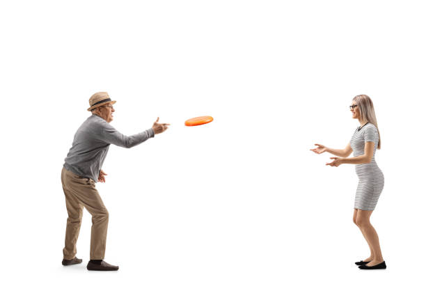 istock Elderly man playing with a plastic disk with a young blond woman 1292735391