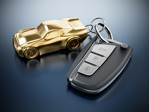 Remote car key connceted to gold car shaped keychain.