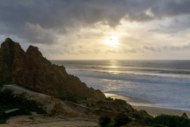 istock bizarre eroded sand dunes on the Atlantic Ocean with waves rolling in at sunset 1292737610