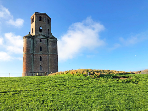 Gothic style red-brick folly built as a castle tower with windows in 1750 by Lord of Horton Manor, now a landmark on the horizon amongst a landscape of agricultural fields and public footpaths