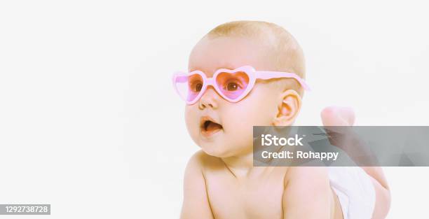 Portrait Of Little Baby Wearing A Summer Pink Heart Shaped Sunglasses And Diapers Looking Away Over A White Background Stock Photo - Download Image Now