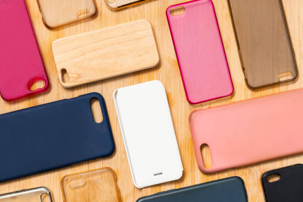 istock Pile of multicolored plastic back covers for mobile phone. Choice of smart phone protector accessories on wooden background. A lot of silicone phone backs or skins next to each other, pattern 1292740238