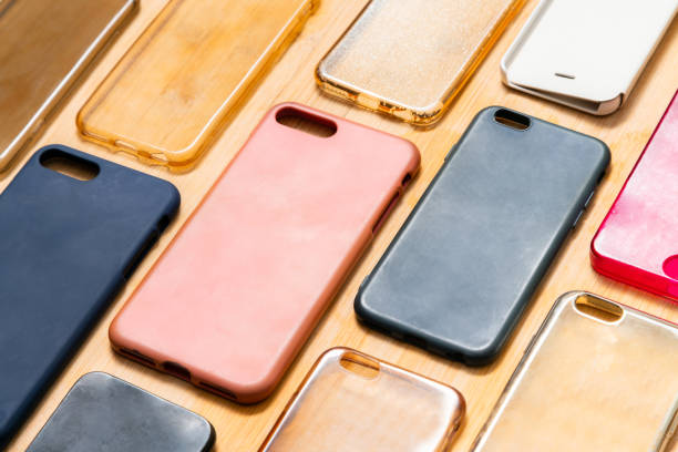 istock Pile of multicolored plastic back covers for mobile phone. Choice of smart phone protector accessories on wooden background. A lot of silicone phone backs or skins next to each other, pattern 1292740322
