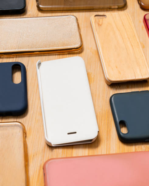istock Pile of multicolored plastic back covers for mobile phone. Choice of smart phone protector accessories on wooden background. A lot of silicone phone backs or skins next to each other, pattern 1292740324