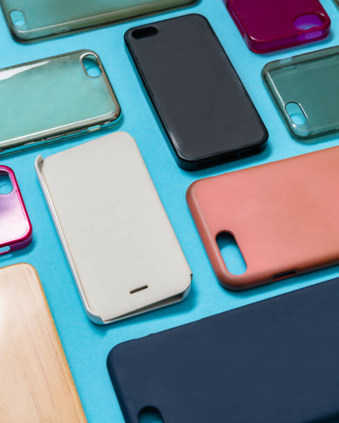 istock Pile of multicolored plastic back covers for mobile phone. Choice of smart phone protector accessories on blue background. A lot of silicone phone backs or skins next to each other 1292740410