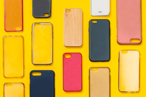 istock Pile of multicolored plastic back covers for mobile phone. Choice of smart phone protector accessories on yellow background. A lot of silicone phone backs or skins next to each other 1292740417