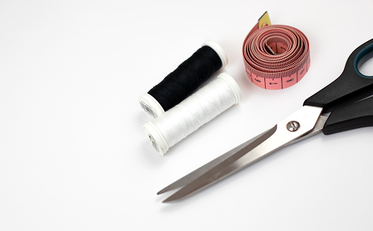 Scissors, tape measure and threads on a white background. Sewing kit