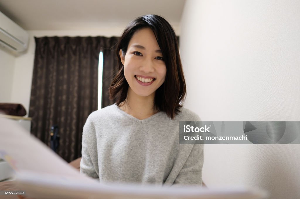 Woman talking in video call Young Asian woman talking in video call from house Japanese Ethnicity Stock Photo