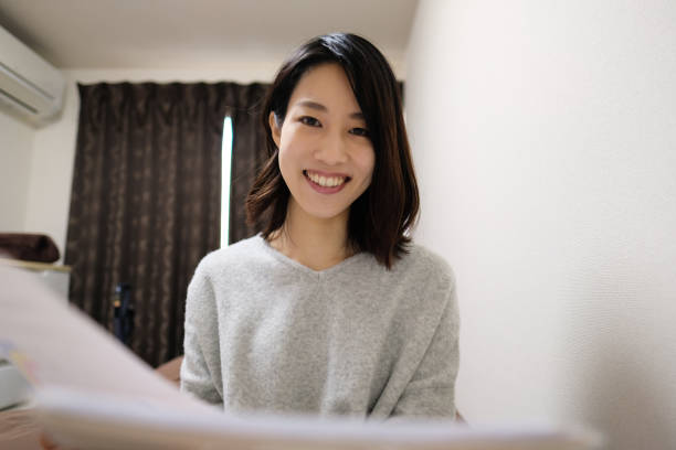 Woman talking in video call Young Asian woman talking in video call from house japanese ethnicity photos stock pictures, royalty-free photos & images