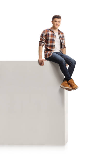 istock Guy sitting on a high wall and smiling at camera 1292744604