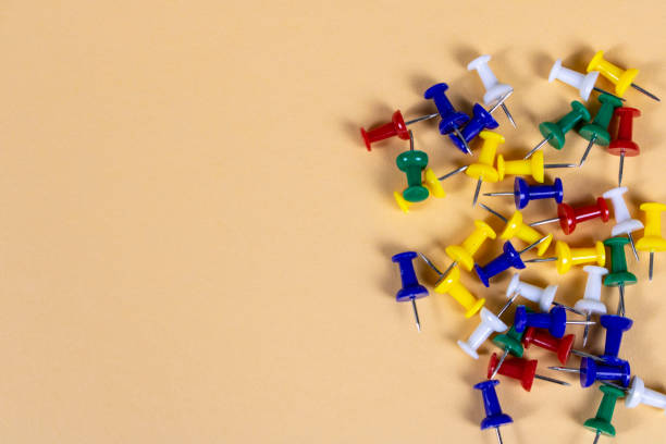 istock Multicolored push pins on the light background. Close up. Selective focus. 1292744684