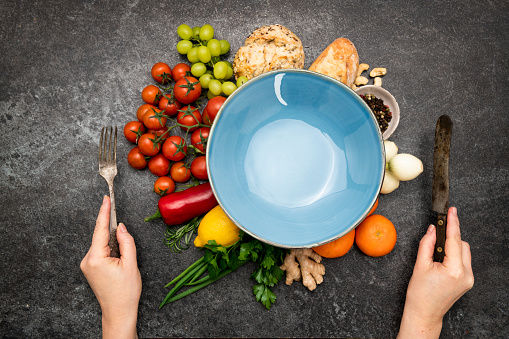 Empty plate and ingredients for breakfast on dark background table