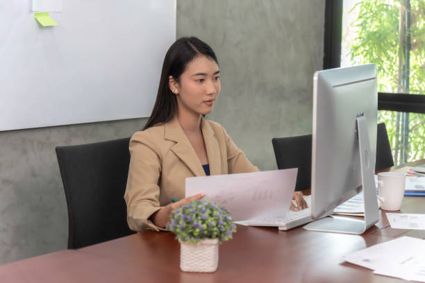 istock Beautiful office woman  sit at table in office ,she work  ,search information on notebook,look friend and smile agreement. 1292747179
