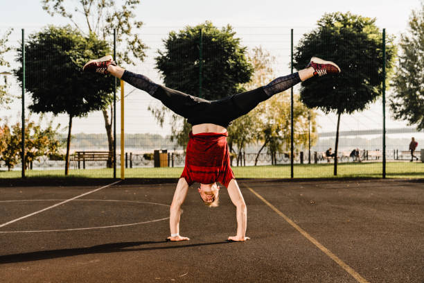 istock Healthy fit strong man standing on his hands on sporting ground 1292748500