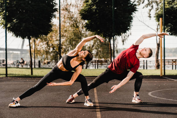 istock Young fit caucasian couple warming-up on the sporting ground 1292748573